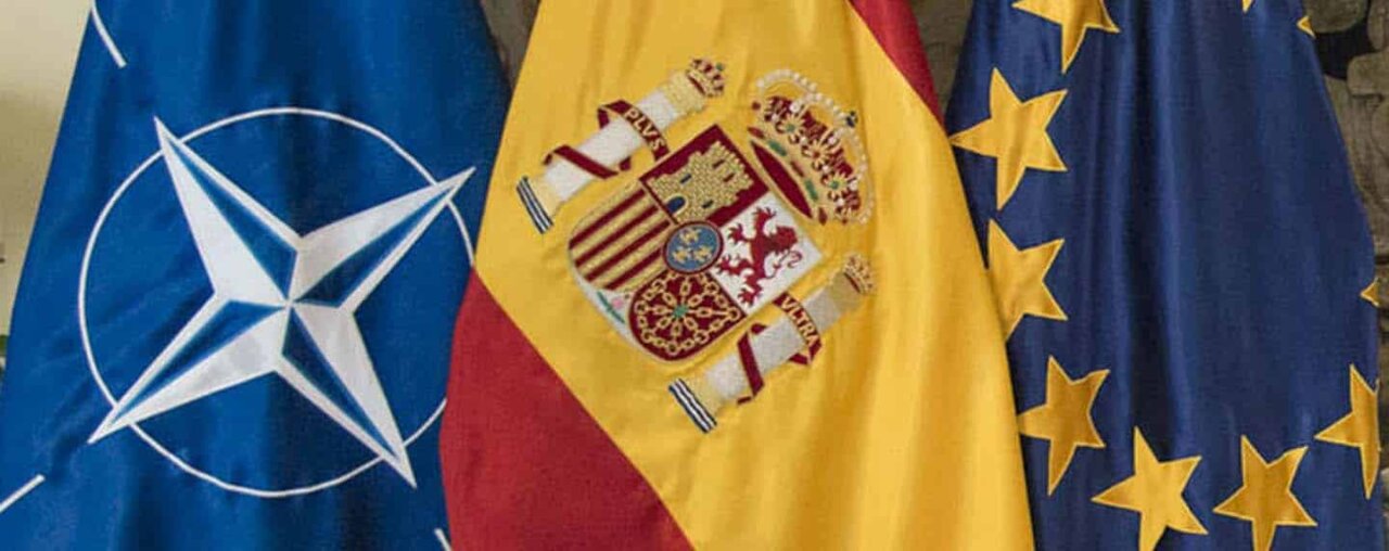 Banderas de España, OTAN y Unión Europea en un evento oficial.
