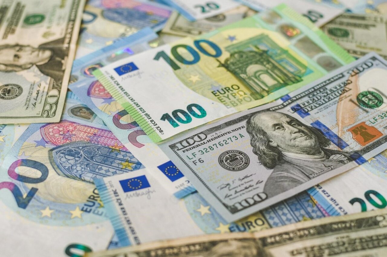 Billetes de euros y dólares sobre una superficie plana