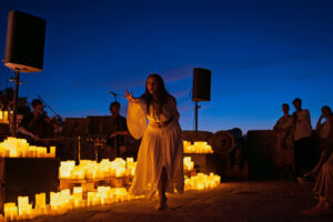 Artista actuando rodeada de velas durante un concierto en Santa Eulària