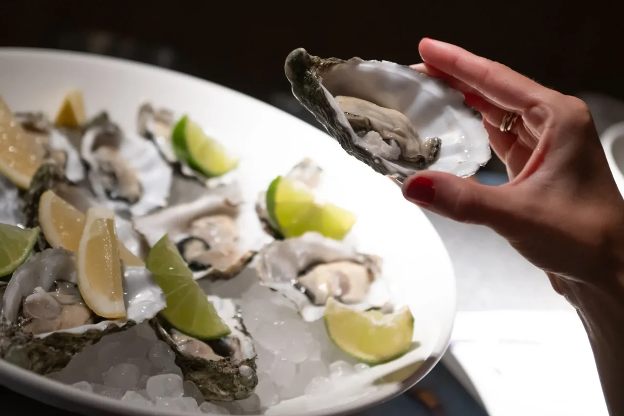 Plato de ostras frescas con limón y lima en evento benéfico