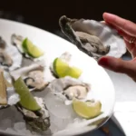 Plato de ostras frescas con limón y lima en evento benéfico