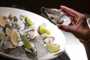 Plato de ostras frescas con lim&oacute;n y lima en evento ben&eacute;fico