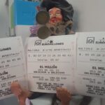 Boletos de Euromillones con números ganadores y muñeca