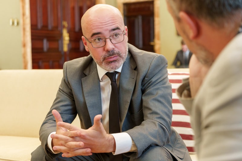 Hombre con gafas y barba discutiendo en una reunión formal