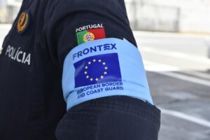 Agente de Frontex con insignia de la policía y bandera de Portugal