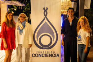 Cuatro personas posando junto a un banner de Fundaci&oacute;n Conciencia