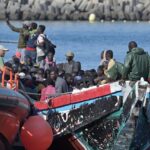 Grupo de migrantes en una embarcaci&oacute;n cerca de la costa