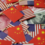 Banderas de China y Estados Unidos sobre billetes de yuan y dólar