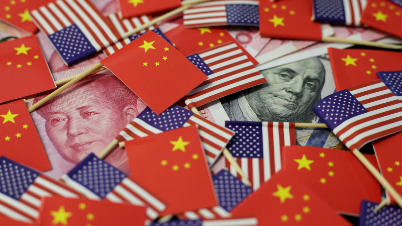 Banderas de China y Estados Unidos sobre billetes de yuan y dólar