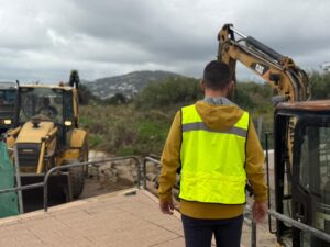 Hombre con chaleco amarillo supervisando maquinaria en una obra