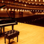 Piano de cola en un escenario vacío de un teatro