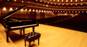 Piano de cola en un escenario vacío de un teatro