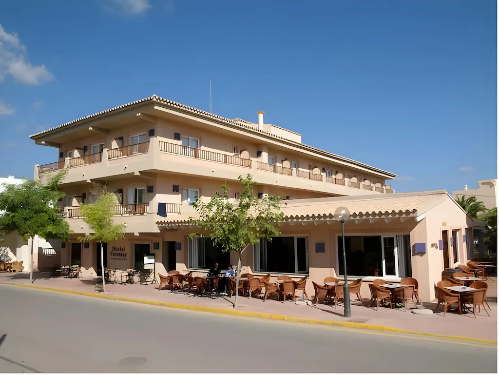 Vista exterior del Hotel Voramar en Formentera con terraza y árboles