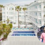 Vista del hotel Es Vive con piscina y palmeras en Ibiza