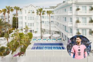 Vista del hotel Es Vive con piscina y palmeras en Ibiza