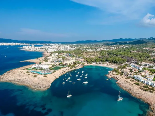 Vista aérea de Ibiza con aguas contaminadas y barcos en la costa