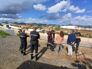 Grupo de autoridades conversando con civiles en un entorno al aire libre