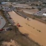 Vista aérea de una carretera inundada en Ibiza con vehículos de emergencia.