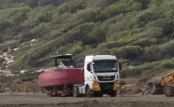 Lancha de lujo siendo remolcada en Es Porroig, Ibiza.