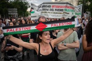 Mujer en manifestación sosteniendo una bandera de Palestina en Madrid.