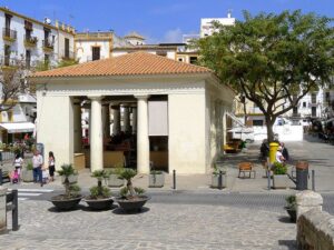 Vista exterior del Mercat Vell de Ibiza con comerciantes y visitantes.