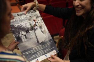 Mujeres sosteniendo un cartel del espectáculo folclórico en Ibiza