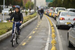 Ciclistas en una vía de Bogotá con tráfico vehicular