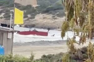 Embarcación roja encallada en la playa tras persecución marítima en Ibiza