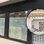 Fachada de un local en Ibiza con ventanas cubiertas y un interior moderno