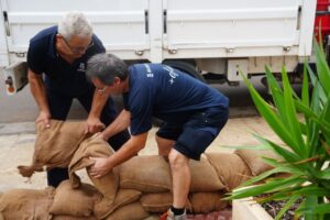 Dos hombres colocando sacos de arena para prevenir inundaciones en Ibiza.