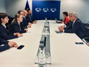 Reunión de funcionarios en un entorno formal con banderas de la UE.