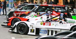 Varios coches de competición alineados en un evento de carreras en Ibiza