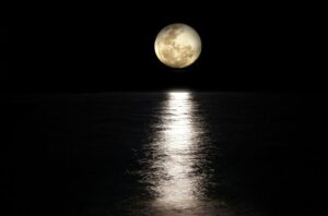 Superluna de la Cosecha reflejándose en el agua durante la noche.