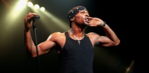 D'Angelo actuando en un concierto con micrófono en mano