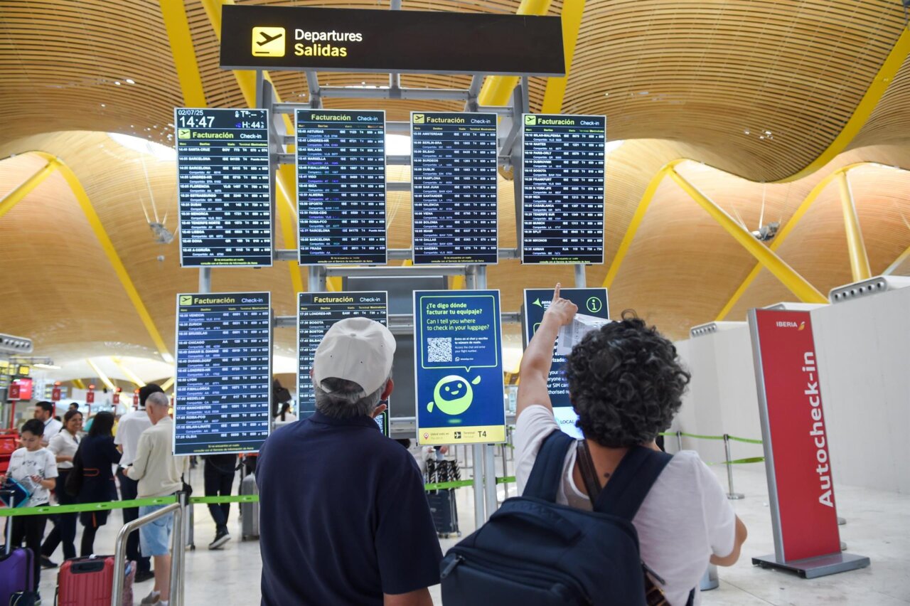 Pasajeros observando la pantalla de salidas en un aeropuerto