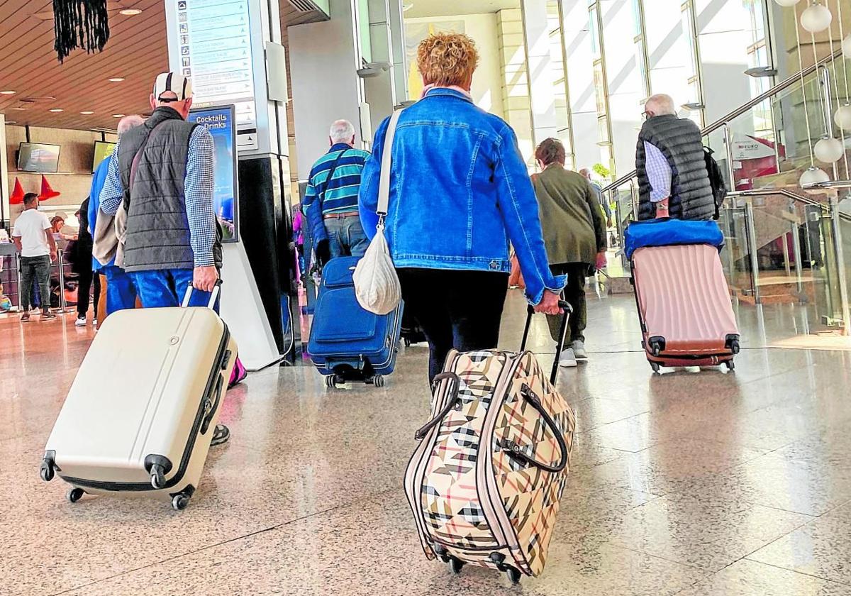 Grupo de personas mayores con maletas en un aeropuerto