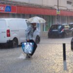 Un hombre cruza una calle del centro de Ibiza bajo un diluvio. EP
